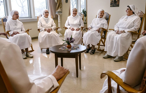 Des religieuses de la communauté des Augustines se bercent et discutent dans une salle commune du Monastère.